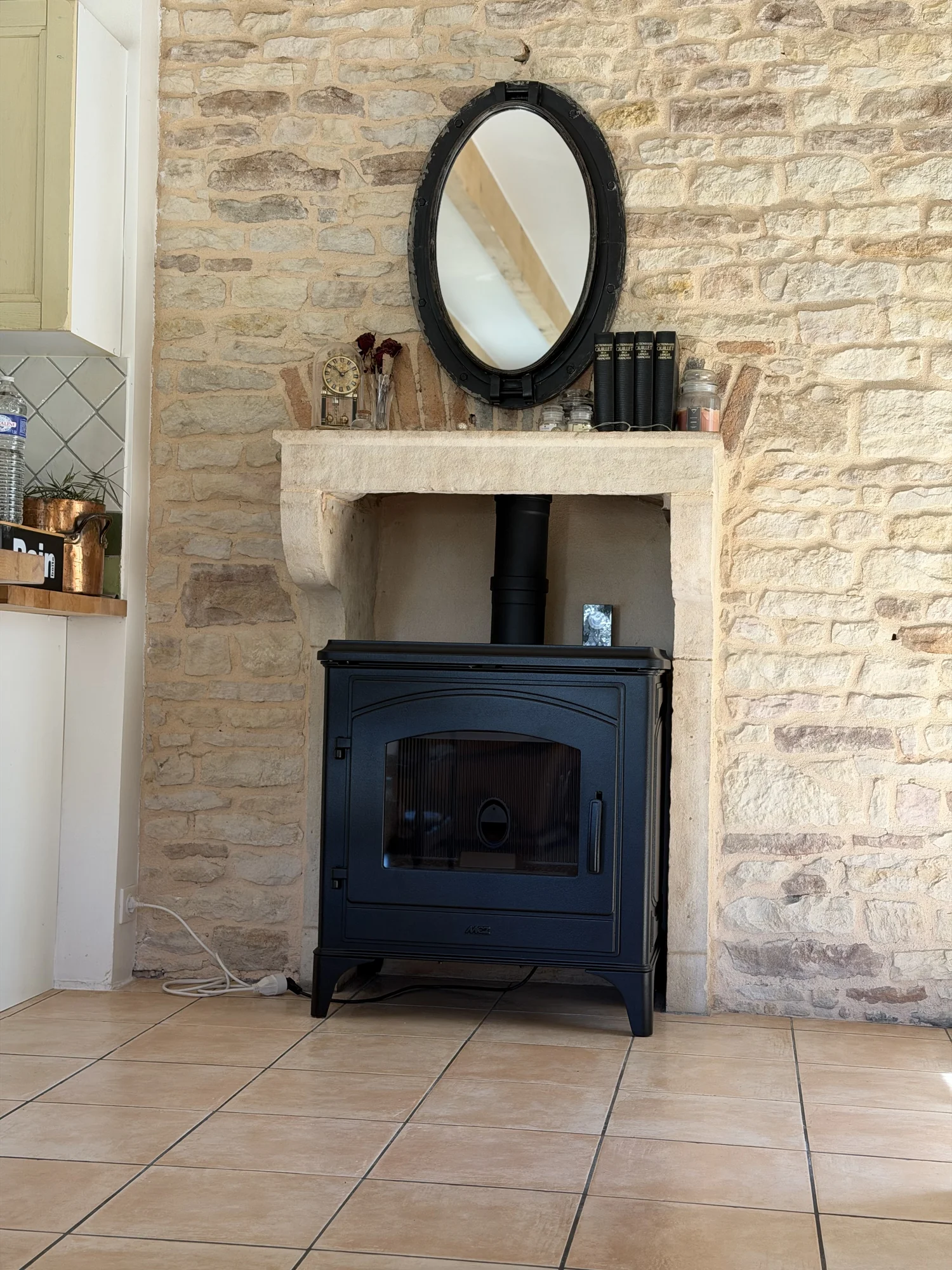 Poêle à granulés en fonte noire dans une cheminée en pierre à Clessé Poêle à granulés en fonte noire dans une cheminée en pierre à Clessé | Flamme Access